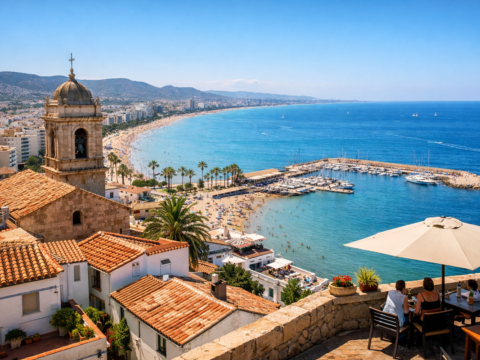 Nadmorskie miasteczko w Hiszpanii z plażą, turkusową wodą i zabudową mieszkalną na wzgórzu